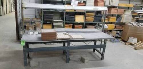 Metal worktable with overhead lights and outlets