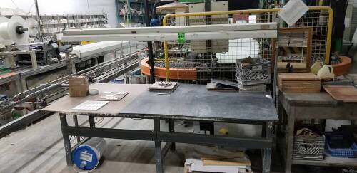 Metal worktable with overhead lights and outlets